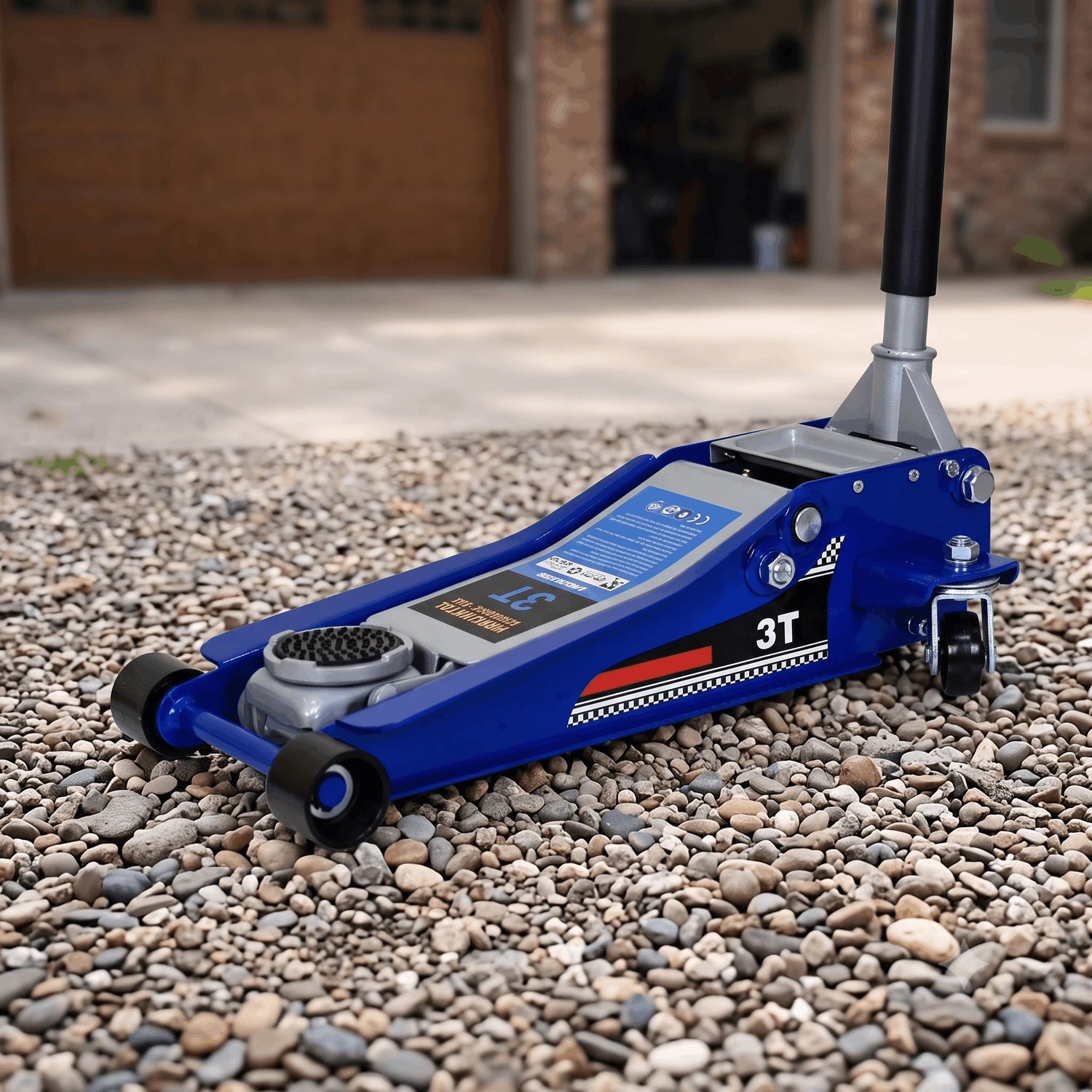 Cric hydraulique 3T extra plat CricPro posé sur une allée de gravier devant un garage